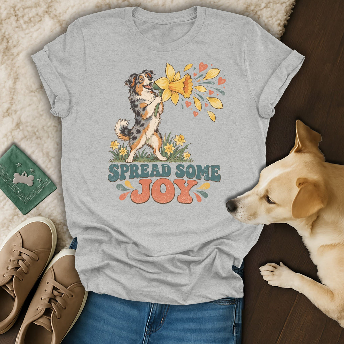 Grey t-shirt featuring an Australian Shepherd graphic, the text "Spread Some Joy," and surrounding lifestyle items.